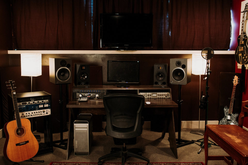Music studio desk with monitors and a chair